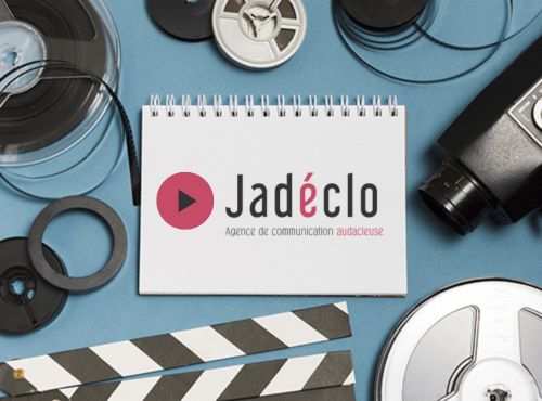 Image d'un carnet avec le logo Jadéclo entouré d'accessoires de tournage
